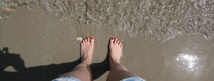 voeten in het zand en zee